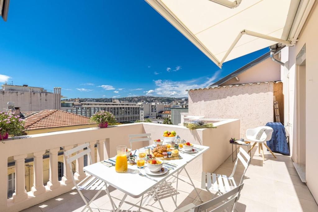 - une table de petit-déjeuner sur un balcon avec vue sur la ville dans l'établissement SPITALIERI- Sunny Terrace with view -New Apartment, à Nice