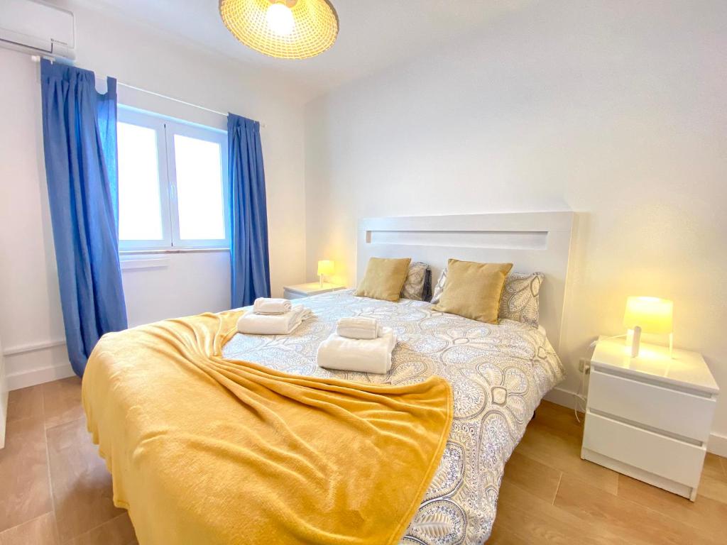 Un dormitorio con una cama grande con dos toallas encima. en Apartamento 2M - Praia do Carvoeiro, en Carvoeiro