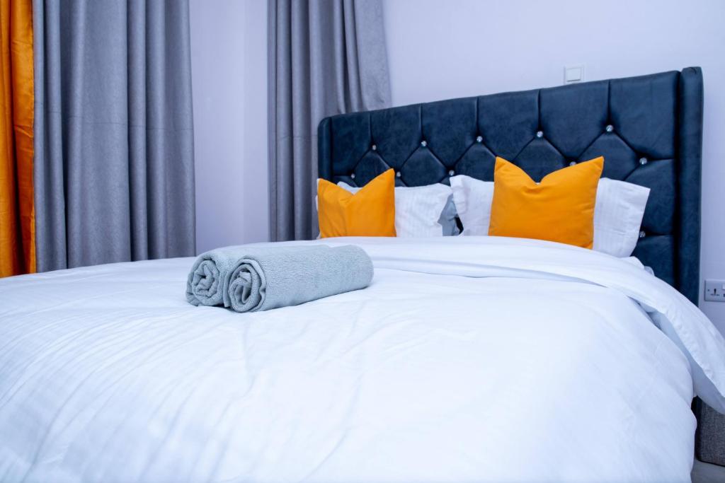 a white bed with a blue towel on it at Quiet a Gem off Thika Highway in Ruiru