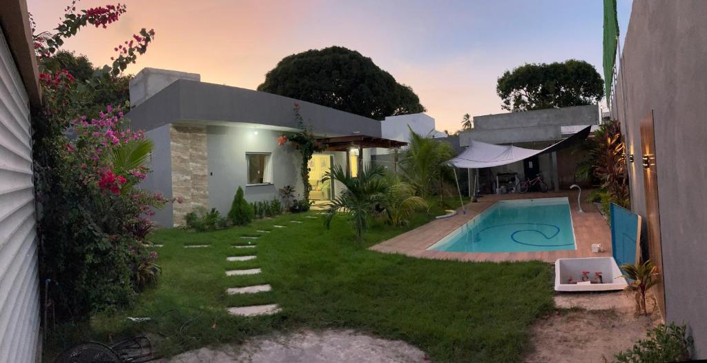 a house with a swimming pool in the yard at Casa temporada in Camaçari