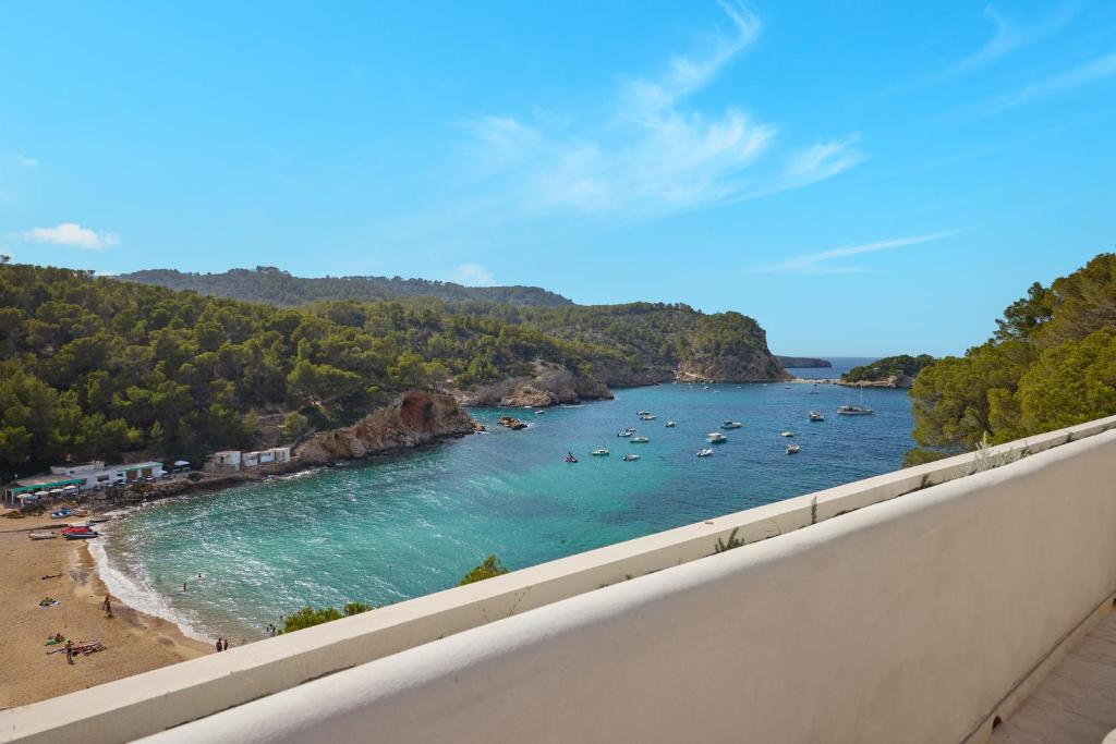 a view of a beach with boats in the water at Cala San Miguel Ibiza Resort, Adults only, Curio Collection by Hilton in Puerto de San Miguel
