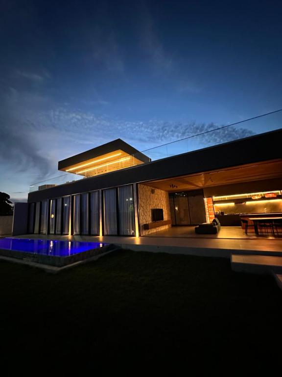 a house with a pool in front of it at night at Paraíso Manguinhos in Serra