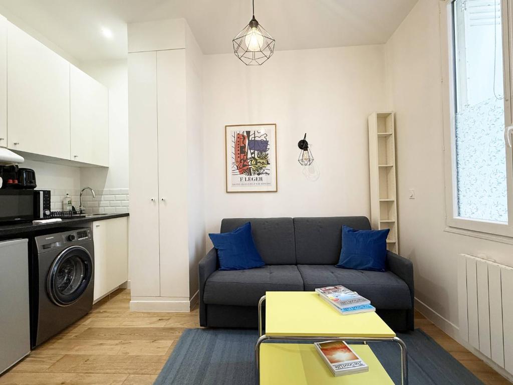 un salon avec un canapé et une table dans l'établissement Charming studio for 2 guest - 2min walk from metro, à Paris