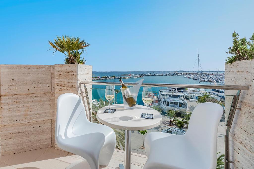 a balcony with a table and chairs and a view of a harbor at Hostal Brisa Marina in Port d'Alcudia