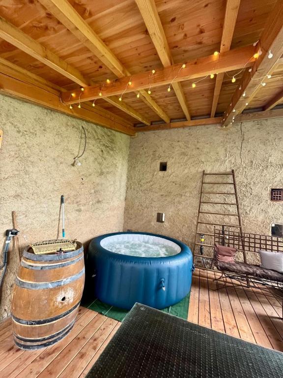 une grande baignoire bleue dans une pièce avec une échelle dans l'établissement Au vieux pressoir, à Montans