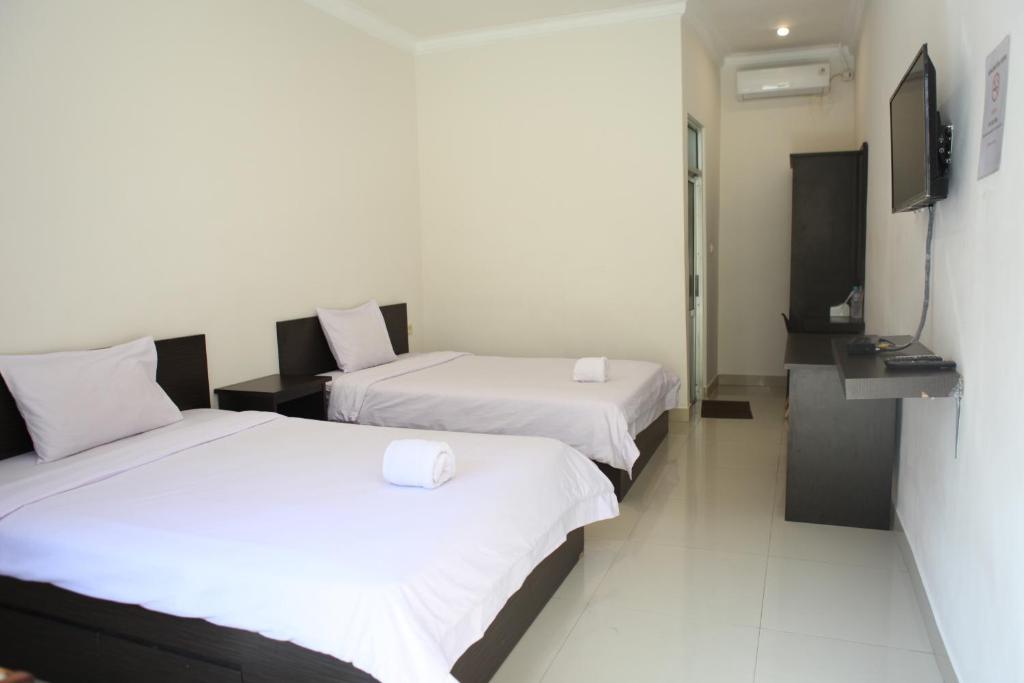 Postel nebo postele na pokoji v ubytování Rahayu Hotel Cirebon