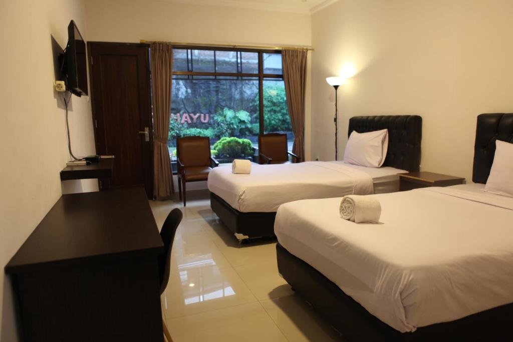 Postel nebo postele na pokoji v ubytování Rahayu Hotel Cirebon