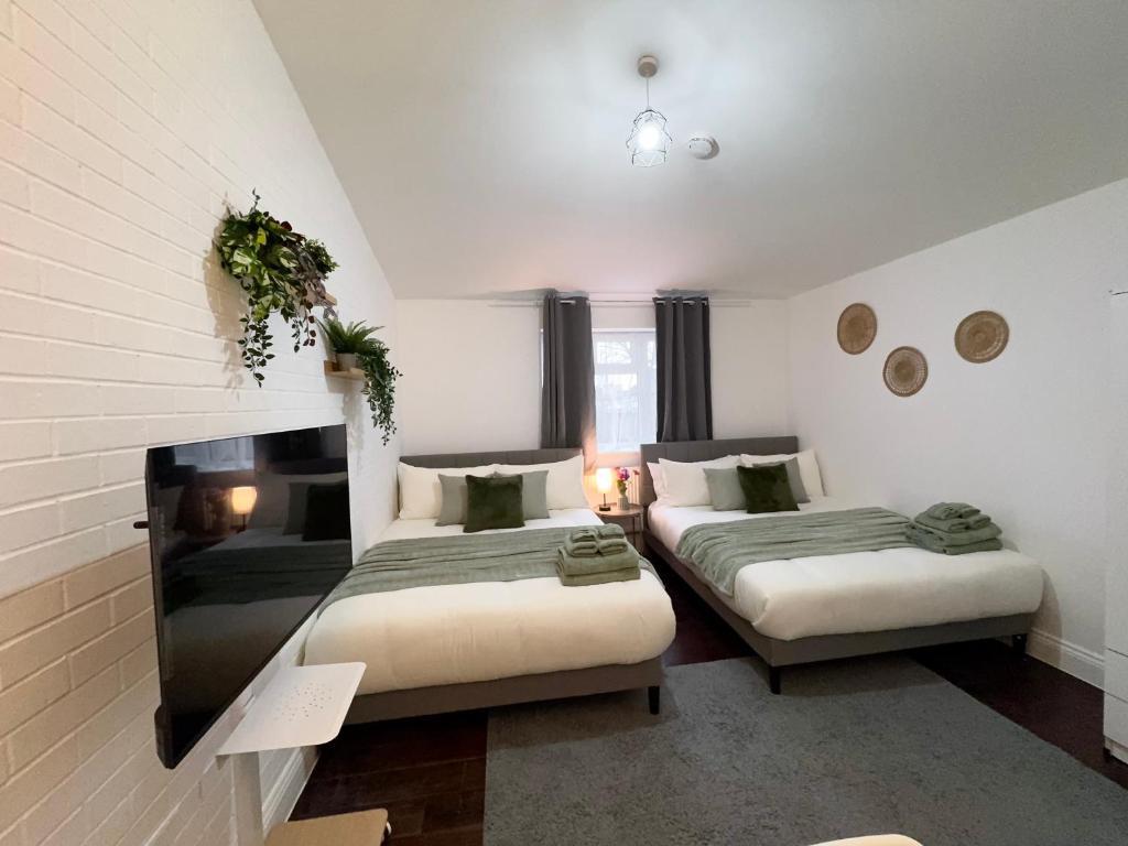 Hotel Family Retreat Studio 30min to Central London, a bedroom with two beds and a fireplace at Family Retreat Studio 30min to Central London in London