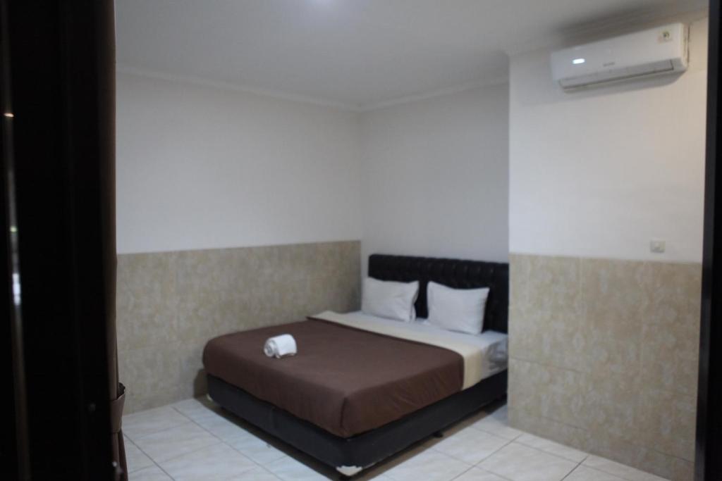 Postel nebo postele na pokoji v ubytování Rahayu Hotel Cirebon