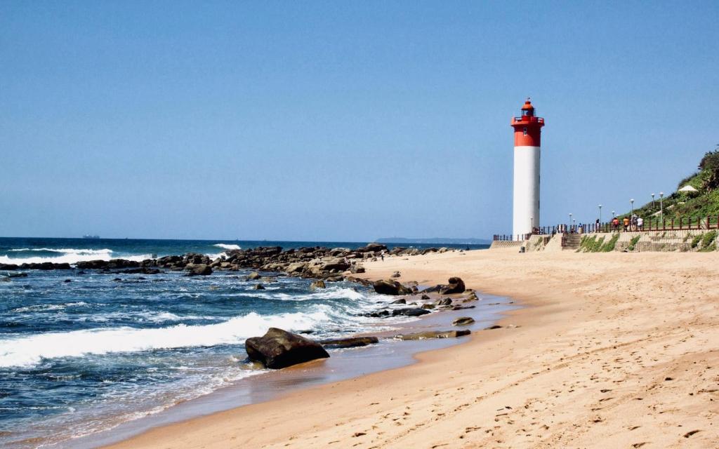 a red and white lighthouse on the beach at Cosy Urban Apartment in Durban