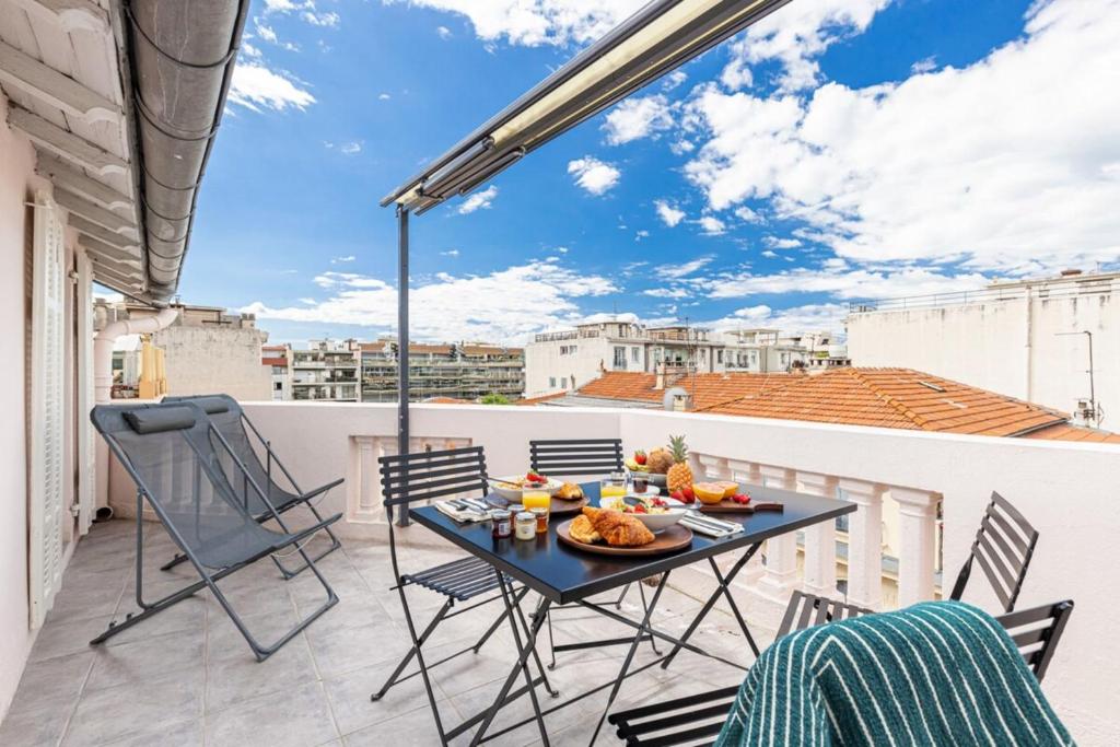 un patio avec une table et des chaises sur un balcon dans l'établissement SPITALIERI 2 - Superb Terrace Panoramic View AC, à Nice