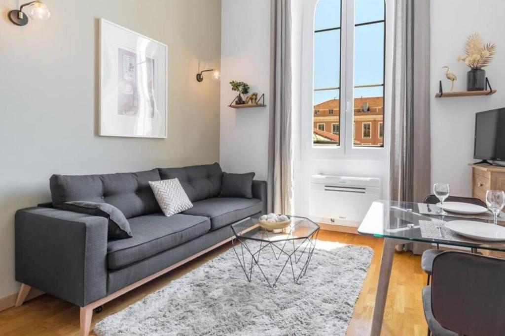 un salon avec un canapé et une table en verre dans l'établissement DELOYE - Spacious Quiet studio wAc near Old Town, à Nice