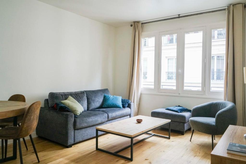 un salon avec un canapé et une table dans l'établissement Nice apartment near the Eiffel Tower, à Paris