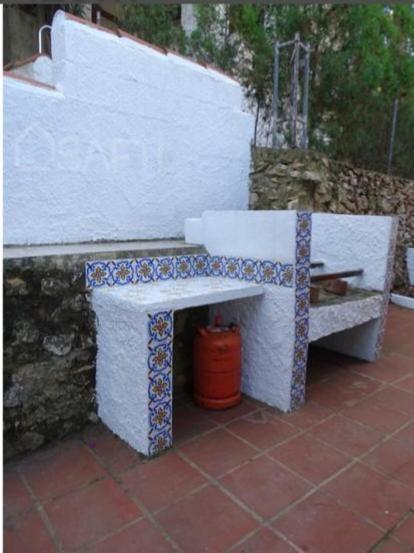 a white bench sitting next to a wall at Casa Elviras in Alcossebre