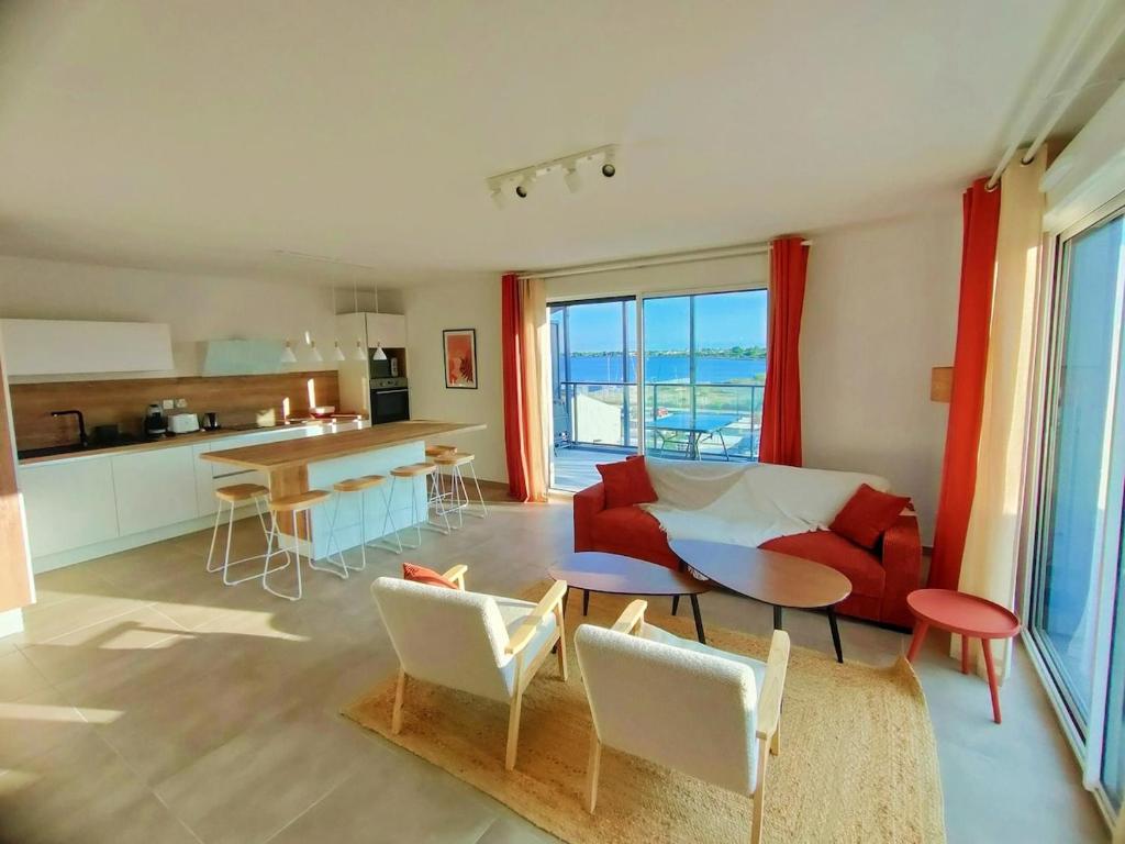 un salon avec un canapé rouge et une table dans l'établissement MILLESIME 5303 : Vue magnifique, spacieux, sur le Port avec parking, à Marseillan