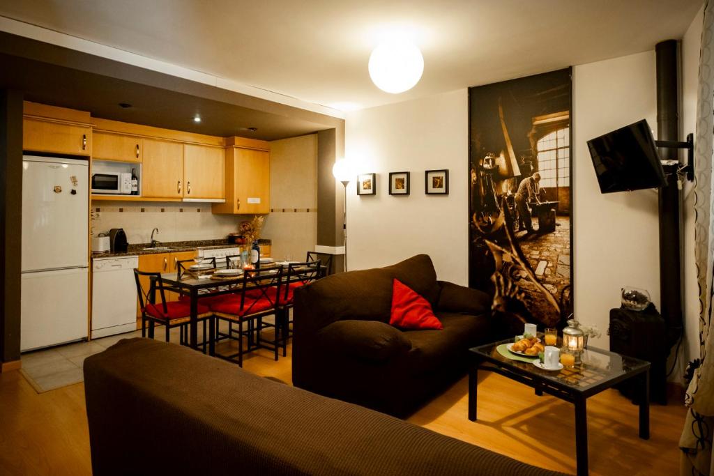 un salon avec un canapé et une cuisine dans l'établissement Inmocyma Antigua Casa Chuanina, bajo-Benasque, à Benasque