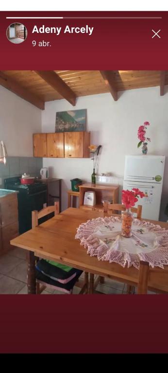 a kitchen with a wooden table with flowers on it at Marcelo Buja in Jardín América