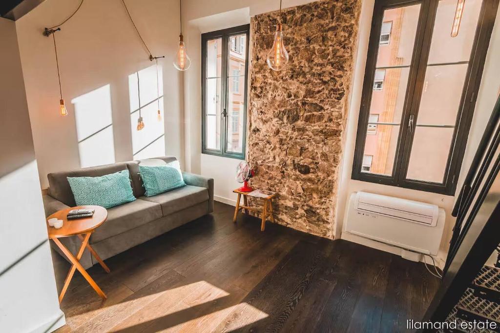 un salon avec un canapé et quelques fenêtres dans l'établissement Studio City Center W Mezzanine 5min From Palace, à Cannes