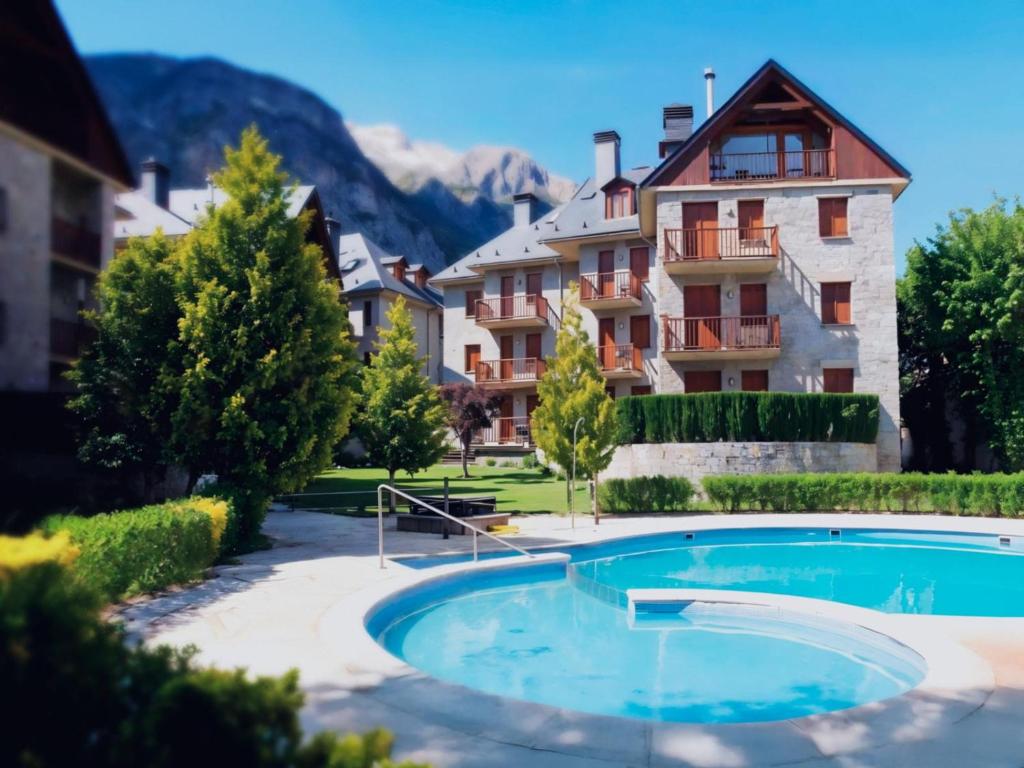 a resort with a swimming pool in front of a building at Villmor - B53 - Coma De Albá, 1º in Benasque