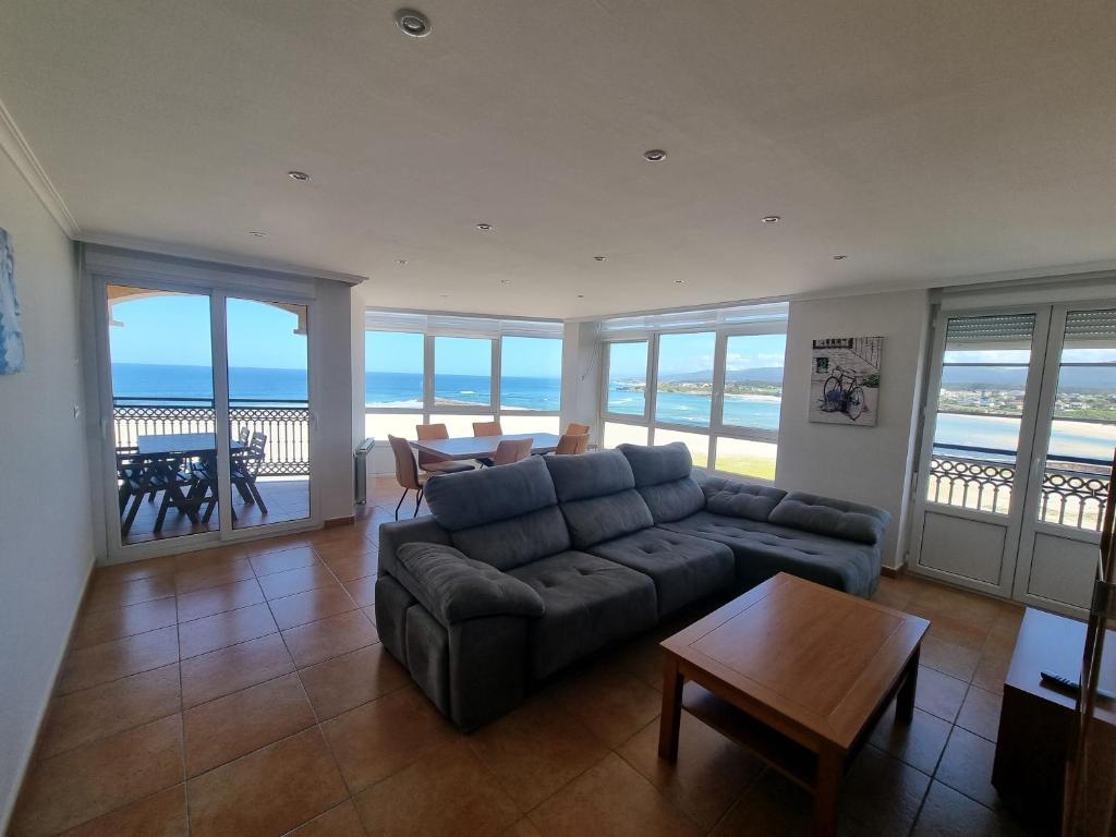 a living room with a couch and a table at Dúplex 4 dormitorios en Playa Rapadoira in Foz