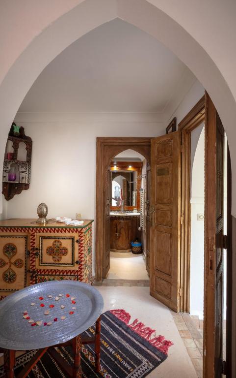 an archway in a room with a table and a hallway at Riad Fleur d'Orient in Marrakech