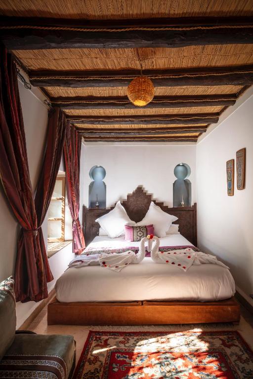 a bedroom with a large bed with a wooden ceiling at Riad Fleur d'Orient in Marrakech