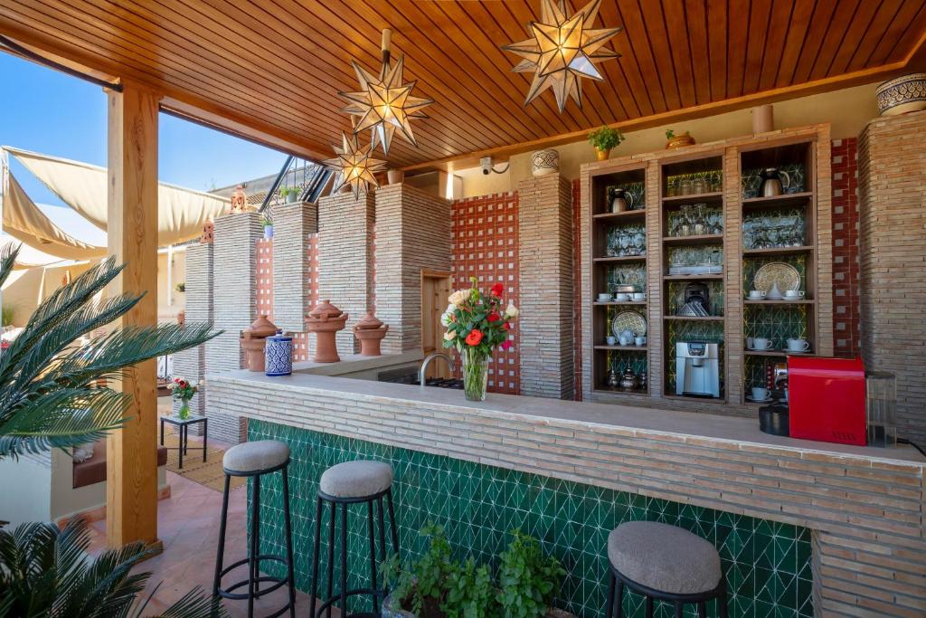a patio with a bar with stools at Riad Fleur d'Orient in Marrakech