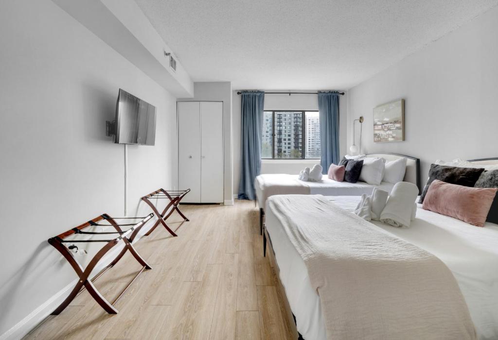 a hotel room with two beds and a television at Luxury Oasis Sleeps 8 King Bed Prime Location in Arlington