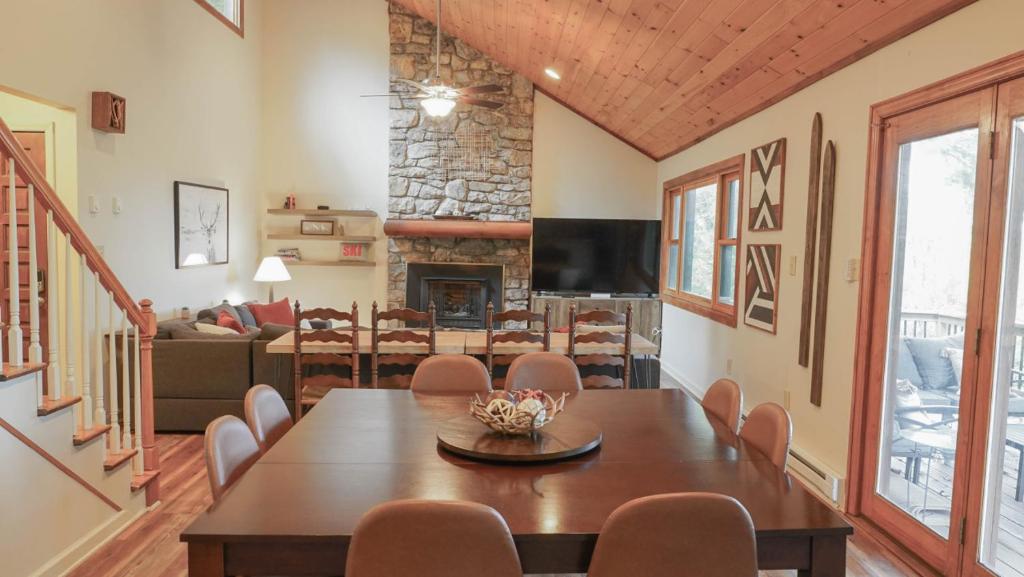 una sala da pranzo con tavolo, sedie e camino di Lookout Lodge - Hot tub, Views, Xbox, Bar a Beech Mountain
