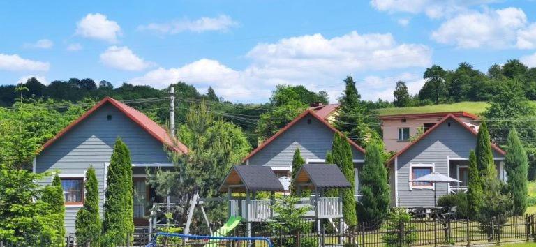 a group of houses with a playground in front at Domki u Polaka in Uherce Mineralne (7)
