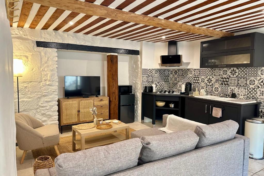 un salon avec un canapé et une table dans l'établissement Au fil de l’eau A cozy nest in the heart of the city, à LʼIsle-sur-la-Sorgue