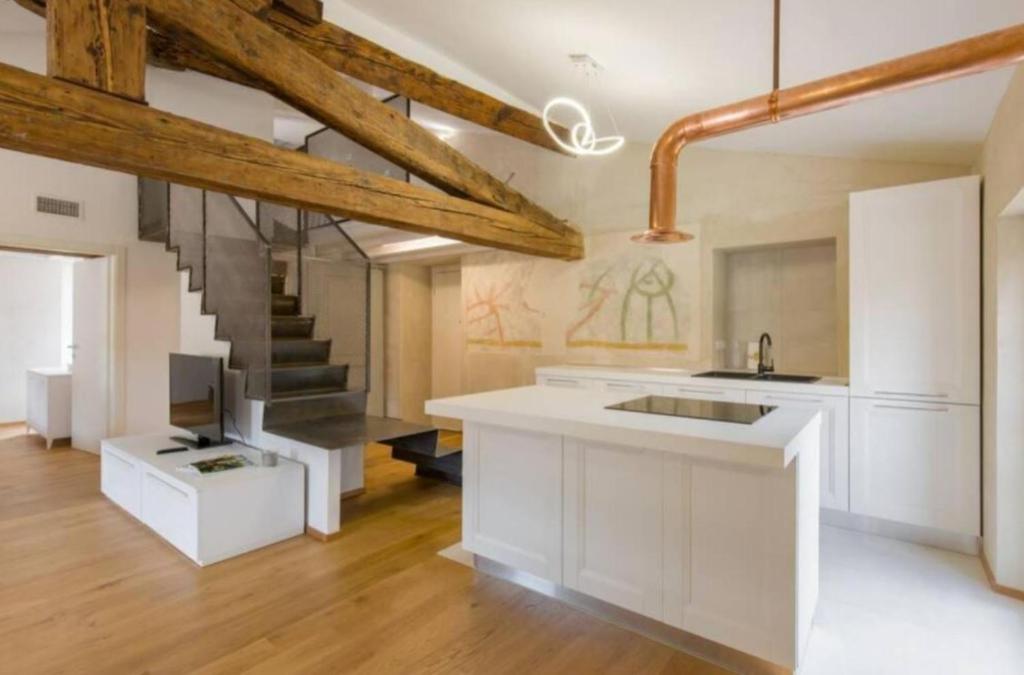 a kitchen with white cabinets and a staircase at Ponte Pietra Luxury Home in Verona in Verona