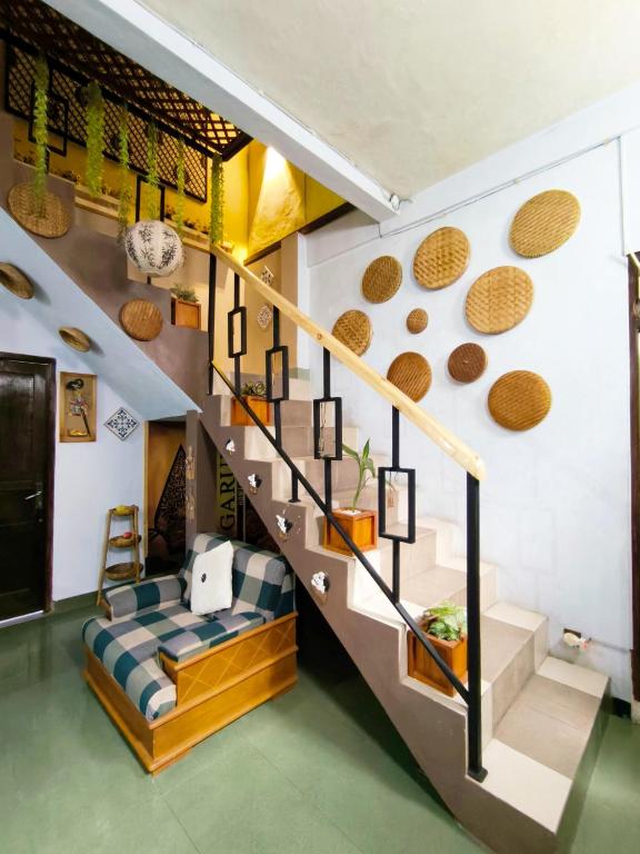 DemanganGaruda Syariah Homestay By Reccoma的带楼梯和沙发的客厅