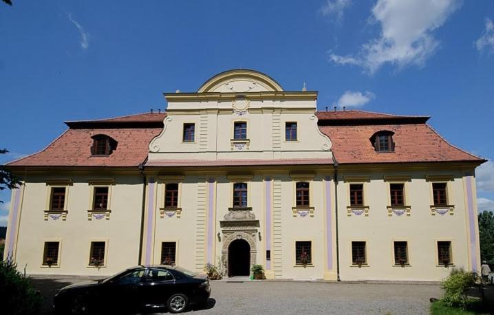 un edificio con un coche aparcado delante de él en Pałac Kietlin, en Niemcza