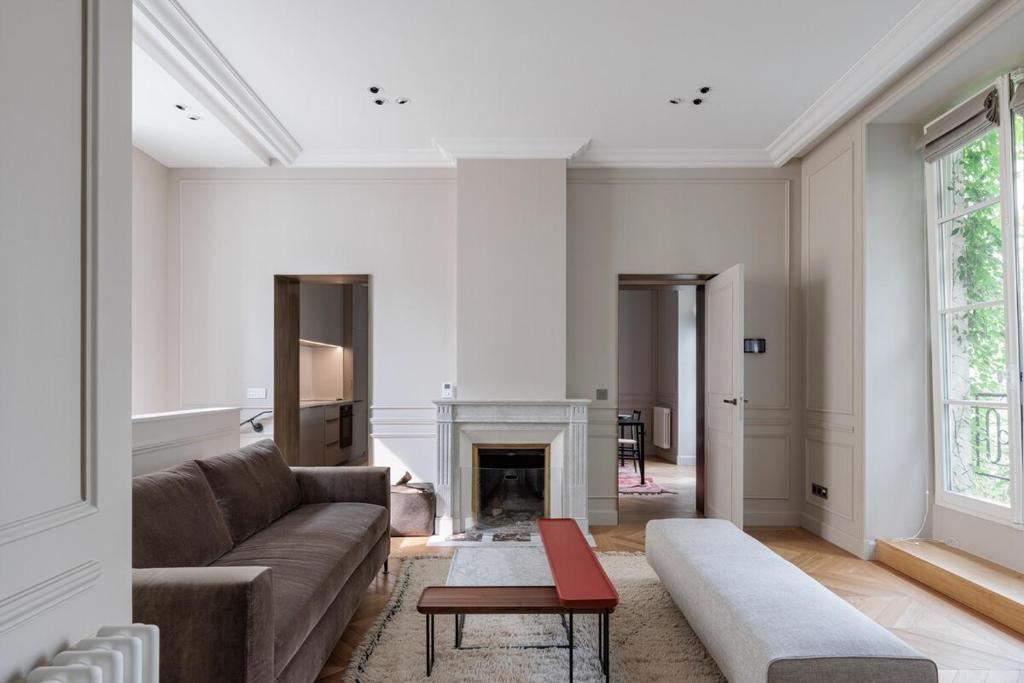 un salon avec un canapé et une cheminée dans l'établissement A mini-suite for 2, in a green setting, à Paris