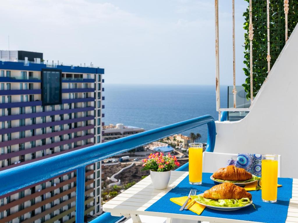 einen Tisch mit Essen auf einem Balkon mit Meerblick in der Unterkunft Wonderful Attic in Playa Paraiso in Playa Paraiso