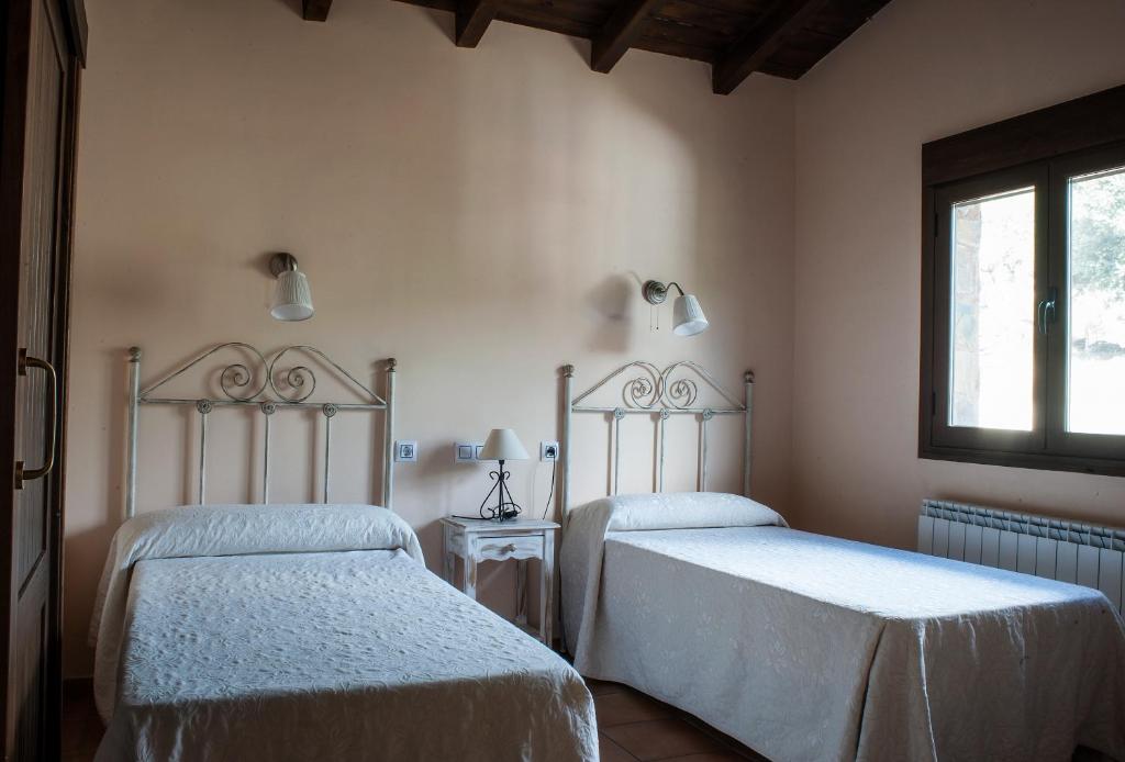 Un dormitorio con dos camas y una ventana. en Ramajal Rural, en Horcajo