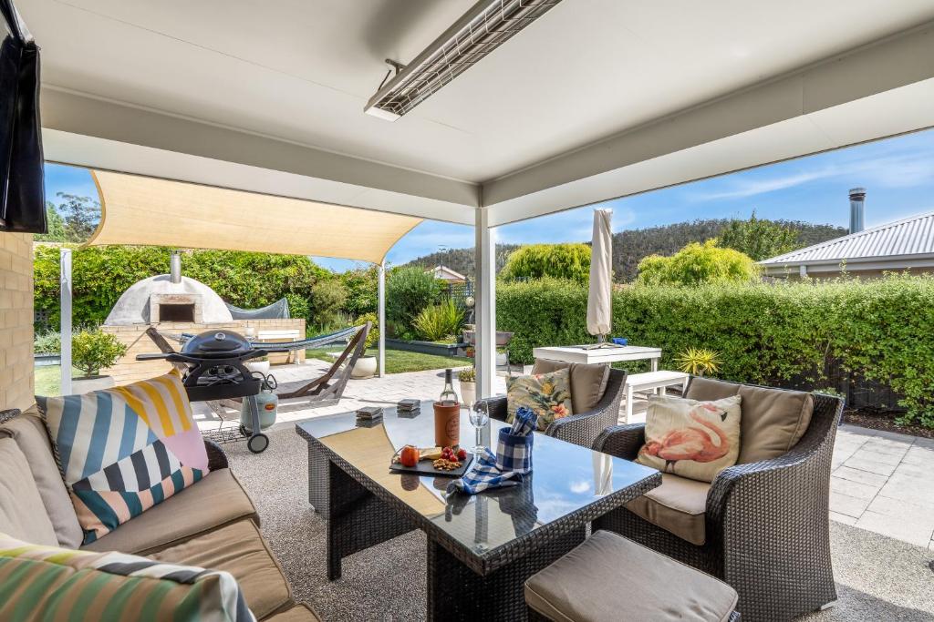a patio with a table and chairs and a grill at Orford Coastal Retreat by Peppy Beach Retreats in Orford