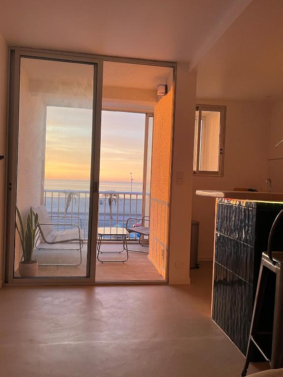 Cette chambre dispose d'une porte coulissante en verre offrant une vue sur l'océan. dans l'établissement Studio face à la mer, à Canet