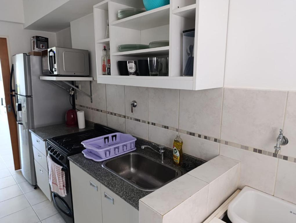 une petite cuisine avec un évier et un réfrigérateur dans l'établissement Apart Paraná, à Paraná