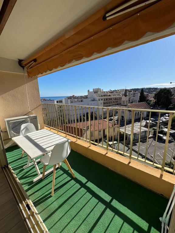 Elle comprend un balcon doté d'une table et de chaises blanches. dans l'établissement Studio ideal pour les vacances, à Roquebrune-Cap-Martin