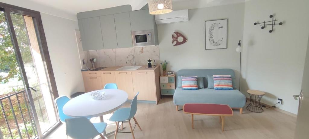 un salon avec une table et des chaises et une cuisine dans l'établissement Collioure au Faubourg T2 à 3min des plages, Clim, avec petit Parking, à Collioure