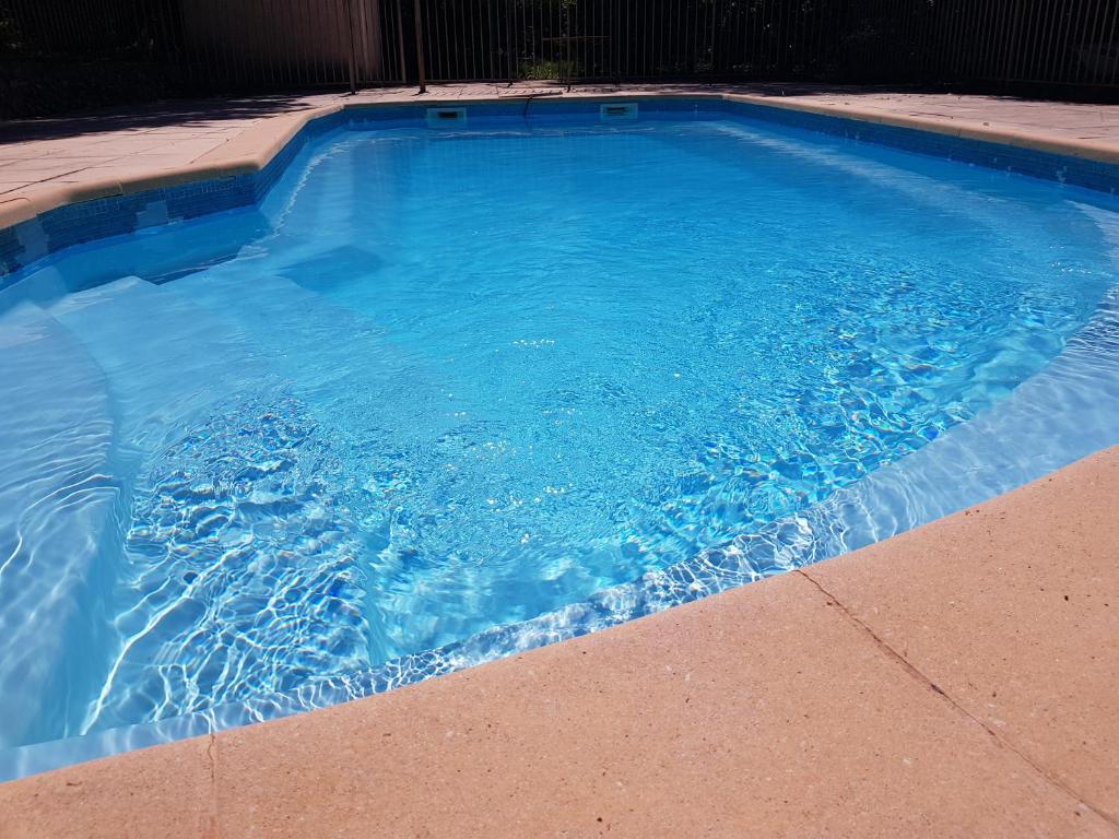 une grande piscine bleue avec de l'eau bleue dans l'établissement Villa La Balle, à La Celle-sous-Gouzon