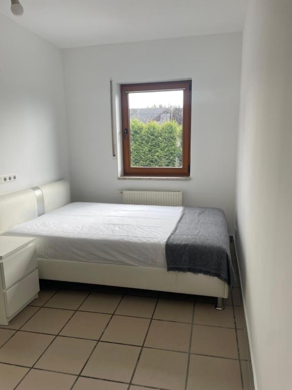 a bedroom with a bed and a window at Viktoria Apartment in Woldert