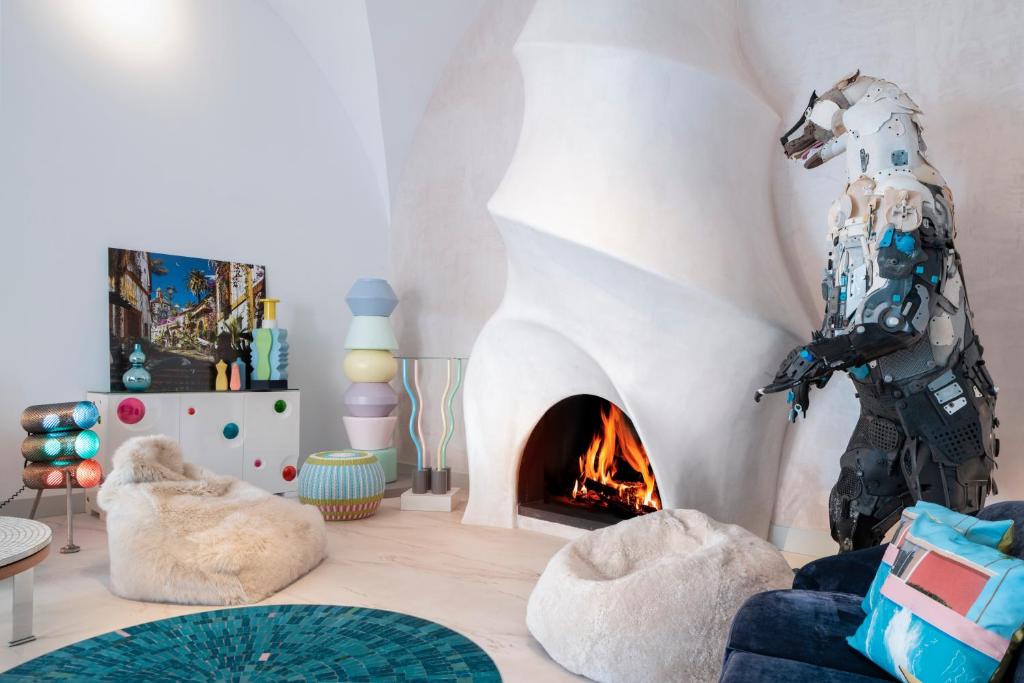 Una sala de estar con chimenea y una estatua de robot. en Hotel Boutique Casa del Limonero, en Sevilla