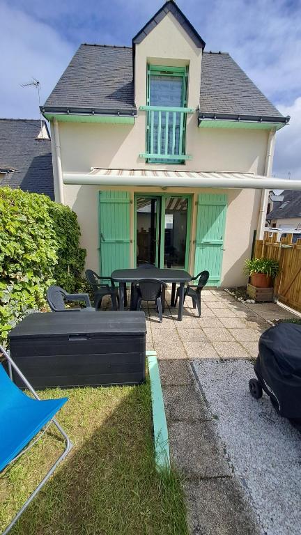 une maison avec un patio avec une table et des chaises dans l'établissement Charmante maison à la Turballe proche de la plage, entre Guérande et Piriac, à La Turballe