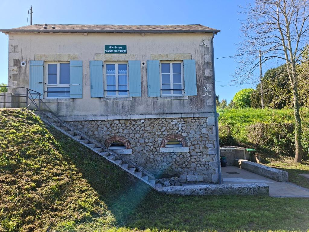 - un vieux bâtiment en pierre avec des volets bleus dans l'établissement Gîte du Cordon de Loire, à Jargeau