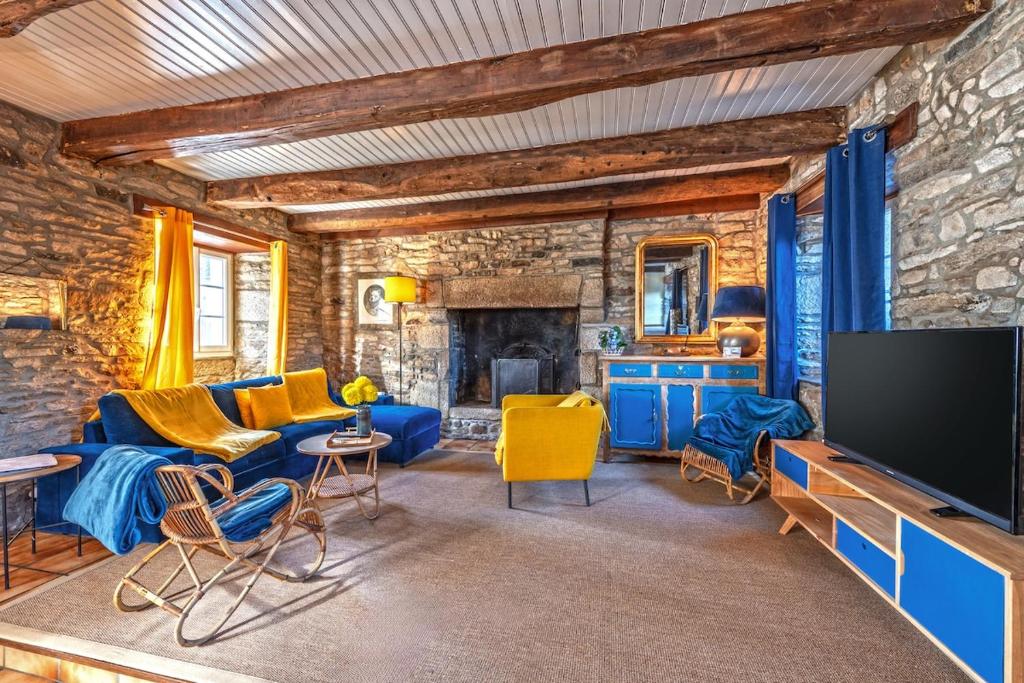 un salon avec un canapé bleu et une télévision dans l'établissement Authentique maison de caractère à Ploumoguer, à Ploumoguer