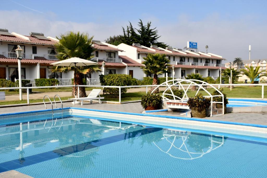 a swimming pool in front of a hotel at Cabañas Rey Pacific in La Serena