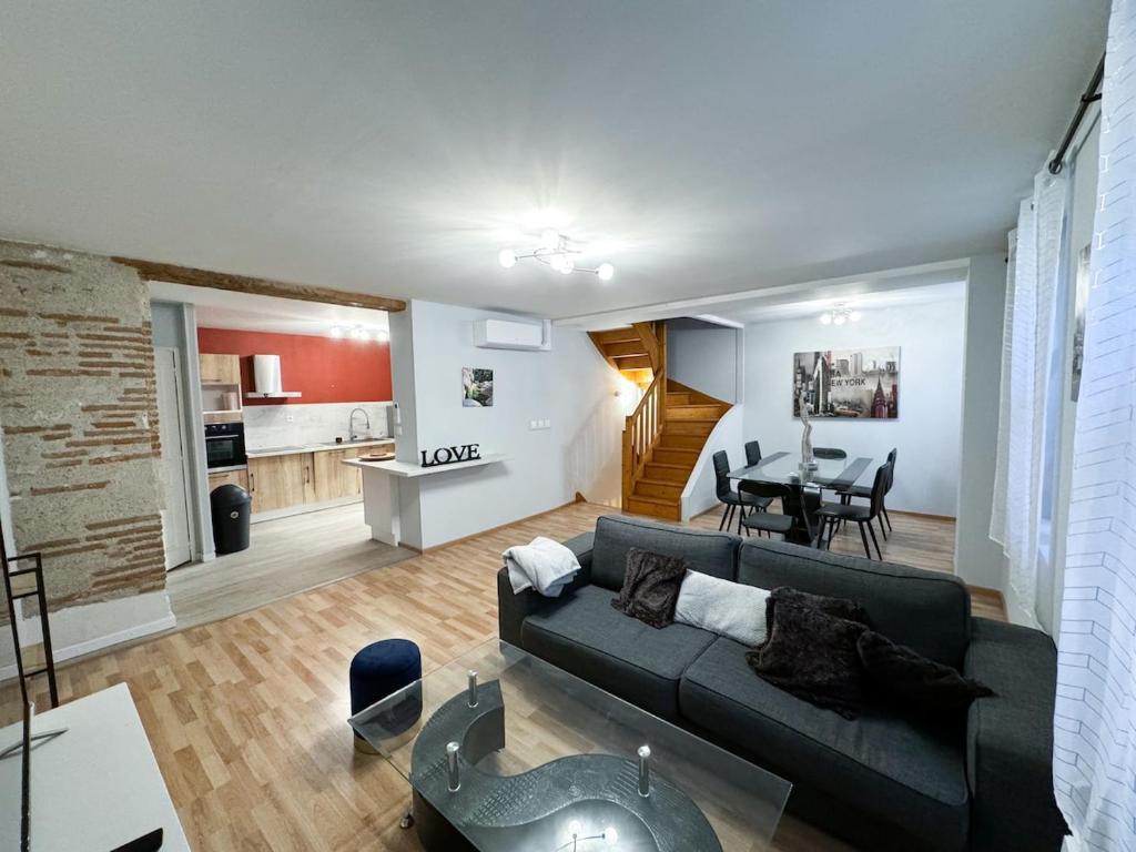 a living room with a couch and a dining room at Maison 3 chambres, Agen centre, climatisé, 6 personnes in Agen
